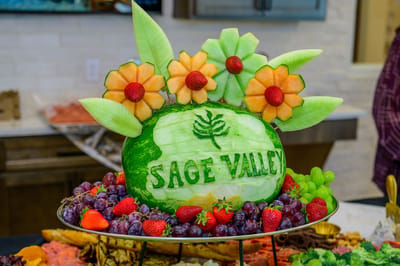 Carved fruit display with flowers and the name Sage Valley