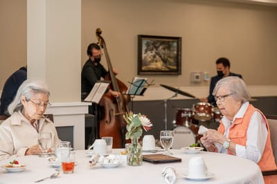 Residents enjoying a meal while music plays in the background