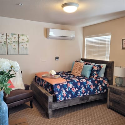 Cozy resident room with floral decor and a brightly made bed