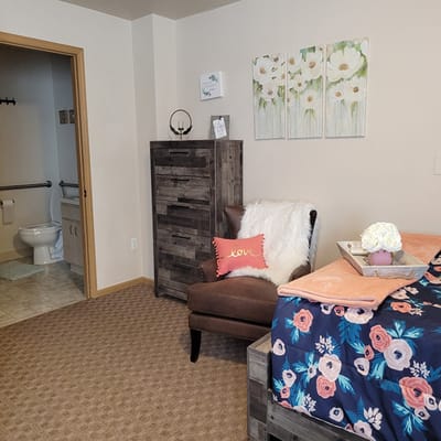 Cozy private resident room with floral decor and chair