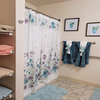 Brightly decorated bathroom with shower and towels