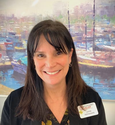 Staff member smiling in a bright lobby area