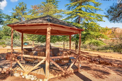 Outdoor gazebo surrounded by trees and seating