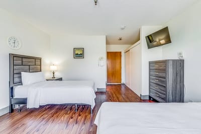 A well-furnished resident room with two beds and a TV