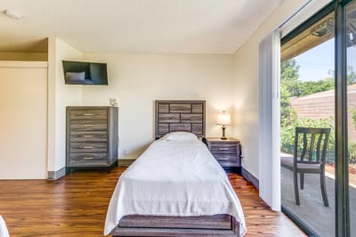 Bright interior of a resident room with single bed and outdoor view