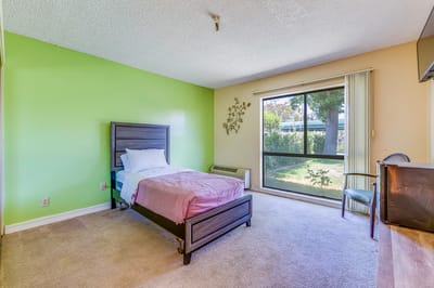A private resident room with a bed and window view
