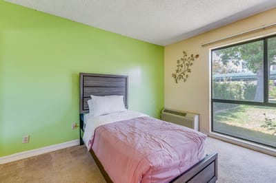 Cozy resident room with a twin bed and large window