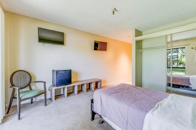 A cozy resident room with a bed and TV