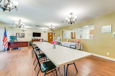 Bright dining area with a large table and flowers