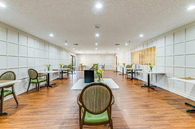Brightly lit dining area with tables and chairs