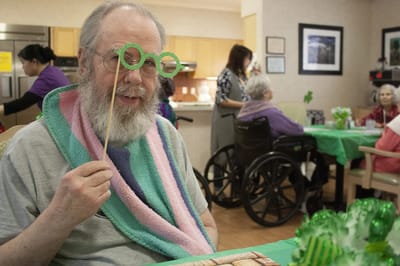 Resident celebrating with festive glasses and decorations.