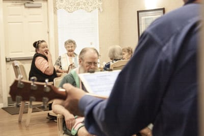Residents enjoying a musical performance in a common area.