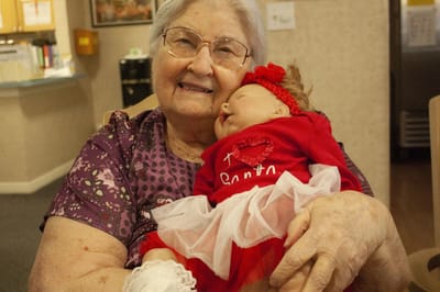 Senior resident with a doll in a care facility