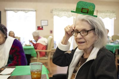 Senior resident celebrating with festive hat.