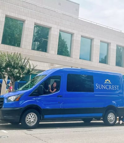 Suncrest transport van with staff inside.