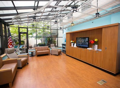 Bright common area with seating and TV.