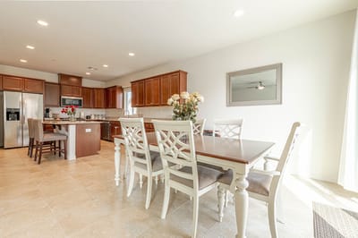 Bright dining area with a wooden table and six chairs.