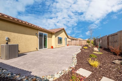 Outdoor patio area with landscaping and clear skies.