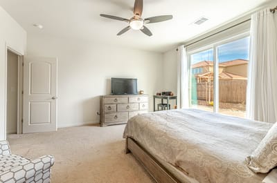 Modern bedroom with light decor and furniture.