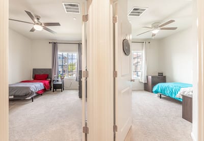 Two shared resident rooms with beds and natural light.
