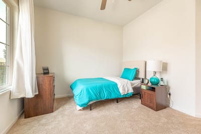 Brightly decorated private resident room with a bed and furniture.