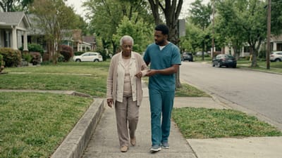 Caregiver assisting a senior woman on a walk.