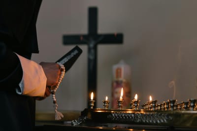 Person lighting candles in a quiet space.