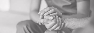 Close-up of two hands clasping each other.
