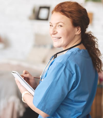 Nurse smiling while taking notes