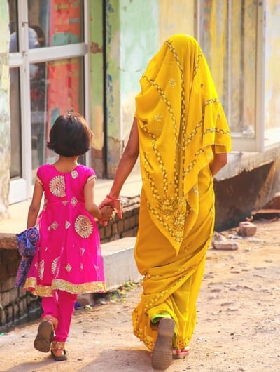 Two women walking hand in hand outdoors