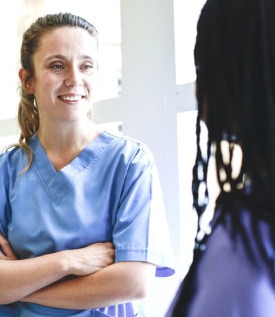 Two staff members having a conversation indoors.