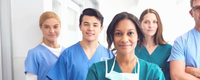 Healthcare staff smiling in a facility hallway.