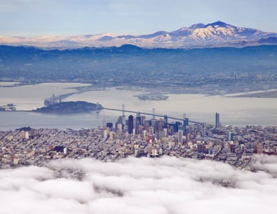 Aerial view of a city with mountains in the background.