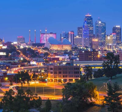A city skyline at dusk with lights.