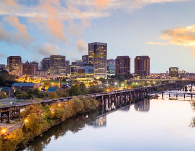 City skyline with river and bridges at dusk.