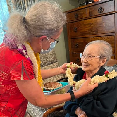 Celebration with a resident receiving a lei