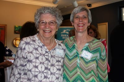 Two smiling women at a community event