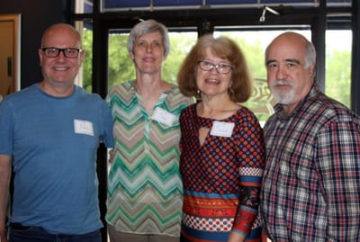 Group of four people with name tags smiling