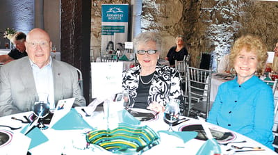 Three residents enjoy a dining event together.