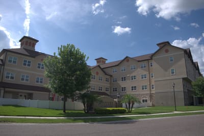Exterior view of a senior living facility with gardens