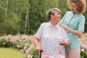 Assisting Hands Home Care – Chandler, home care in Chandler, AZ — Senior caregiver assisting an elderly woman in a garden