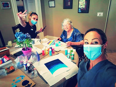 Residents and staff engaged in a painting activity