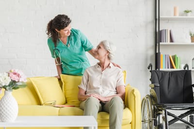 A caregiver interacting with a senior woman in a cozy interior.