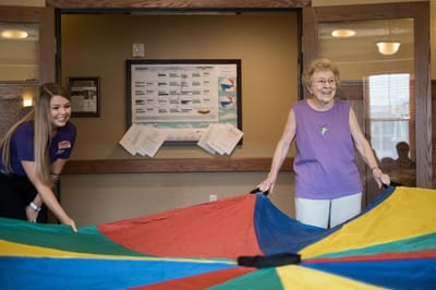 A staff member and resident engaging with a colorful activity