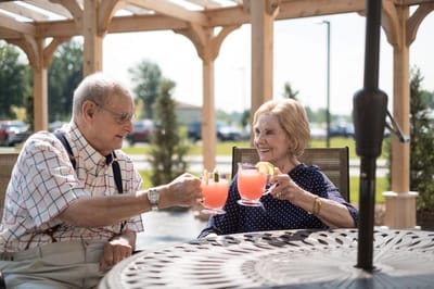 Two residents enjoying drinks on an outdoor patio