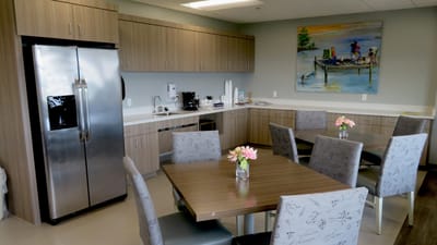Brightly lit kitchen and dining space with tables and chairs