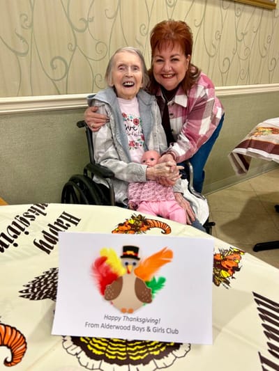 A resident and staff member celebrate Thanksgiving together