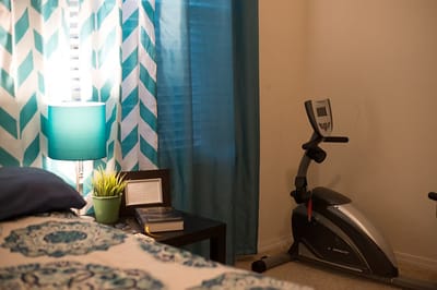 Cozy bedroom with exercise equipment and curtains