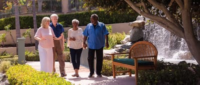 Residents and staff enjoying a walk by the garden.
