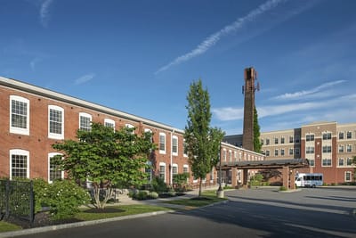 Exterior view of American House Keene with landscaping and transport van